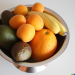 DALL·E 2023-03-11 15.17.58 - A silver bowl with oranges, bananas, avocados, apricots